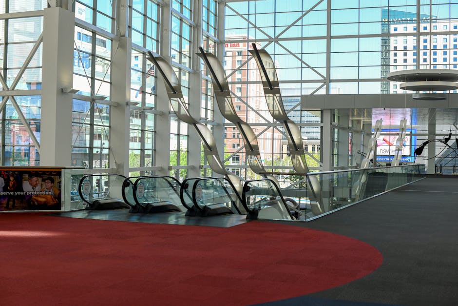 Spacious interior of the Denver Convention Center with escalators and glass facade.